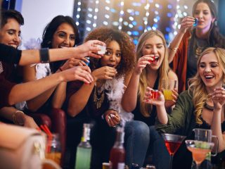 Cropped shot of a group of friends having shots together at a party